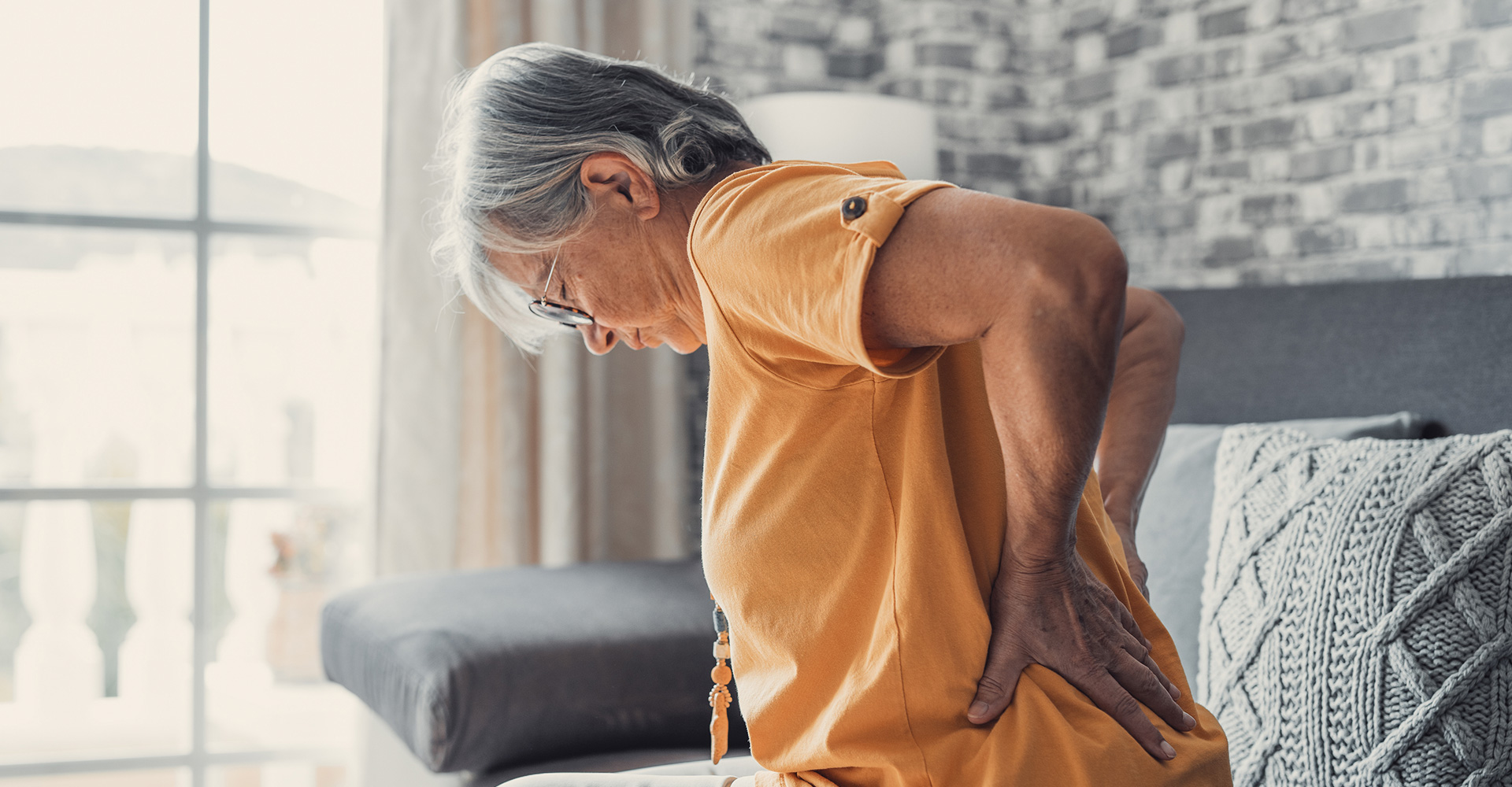 Aged person suffering from back pain, seeking Chronic Pain treatment in Chicago and Downers Grove
